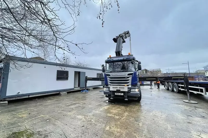 A long modular office unit loaded on the lorry for delivery
